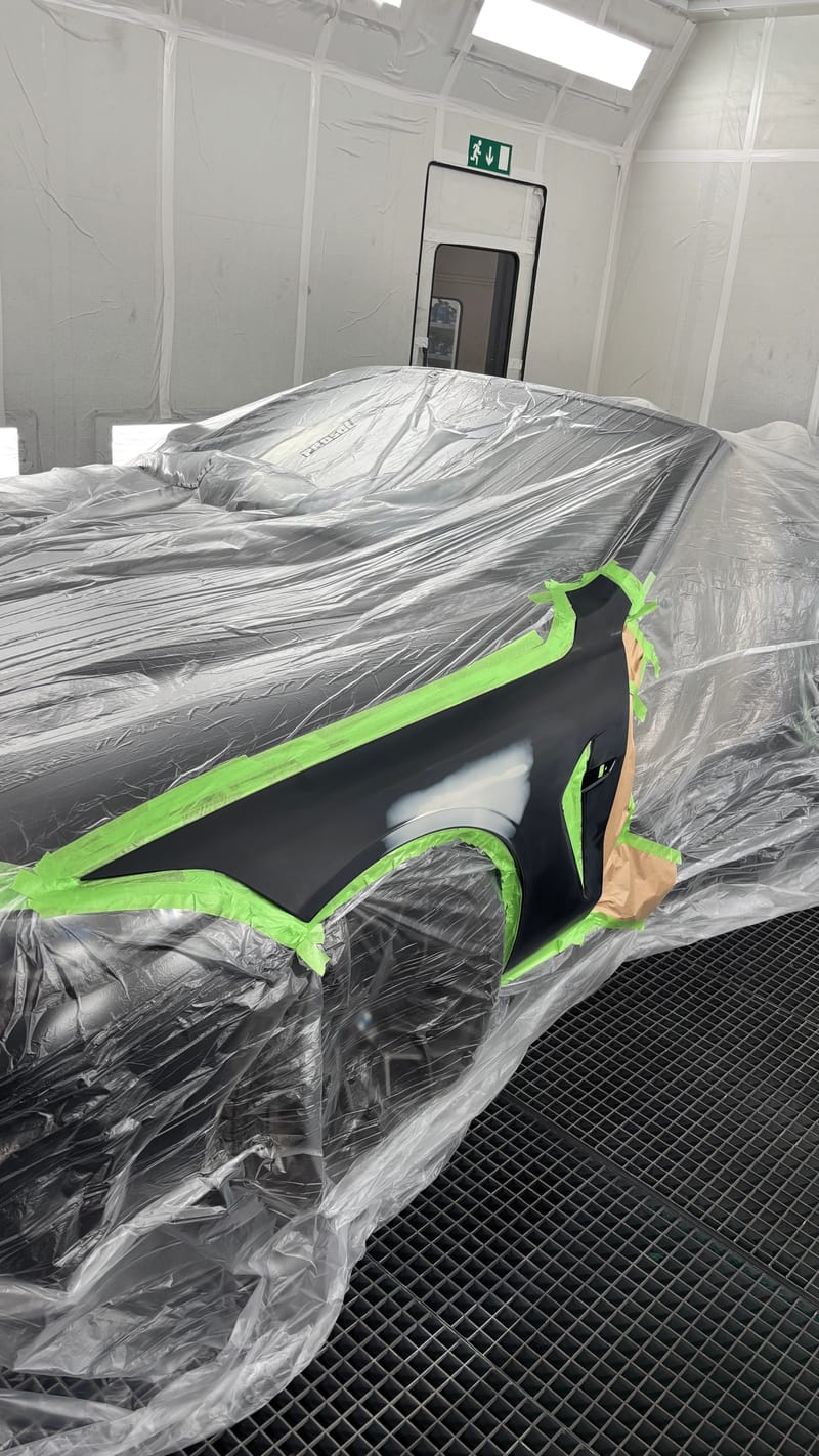 Wagen in der Kabine, mit Folie abgedeckt, der Kotflügel abgeklebt