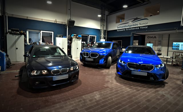 Blick in die Halle mit drei BMW vor dem Firmenlogo, Startpunkt des Rundgangs