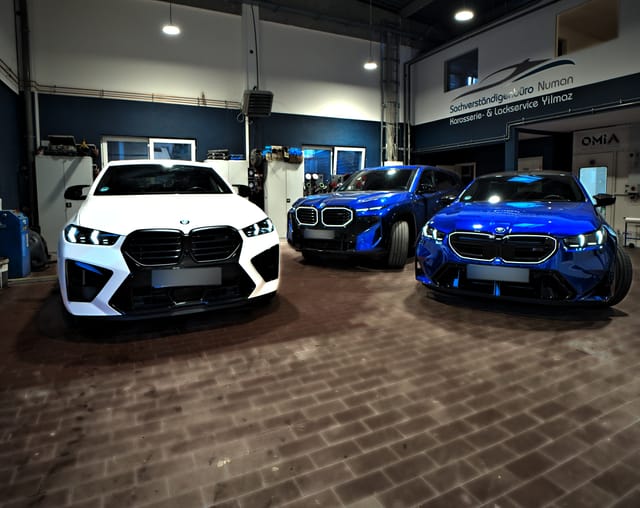 Weißer BMW X6 M, BMW XM und BMW M5 in der Halle